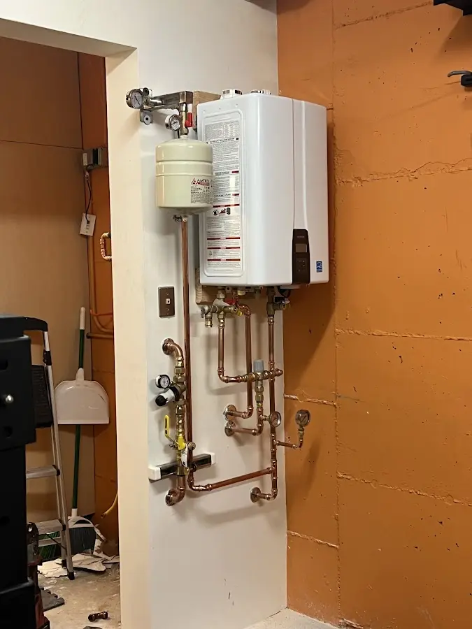 Plumbing technician inspecting water heater connections in Windsor Locks